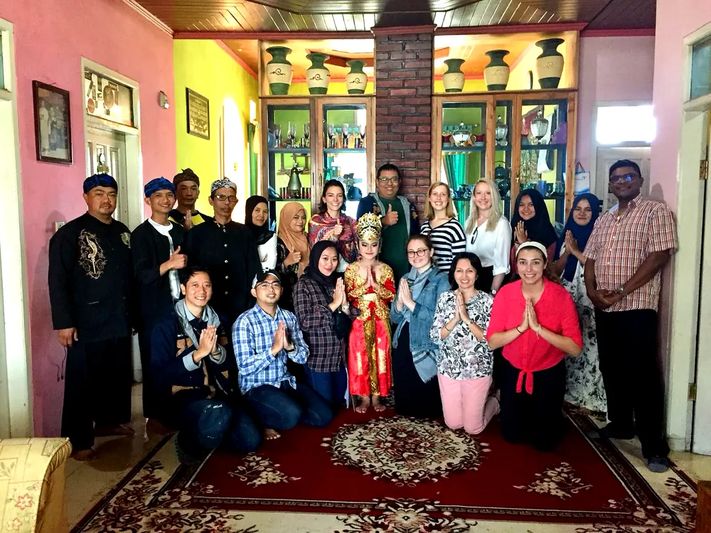 Students welcomed by a community in traditional Javanese dress during a cultural immersion program in Indonesia